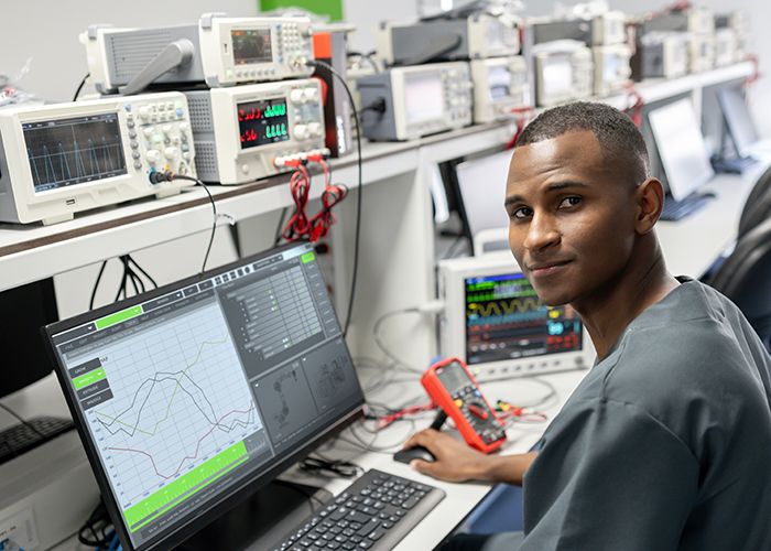 A male technician monitors the readings on several cardiac measuring machines.