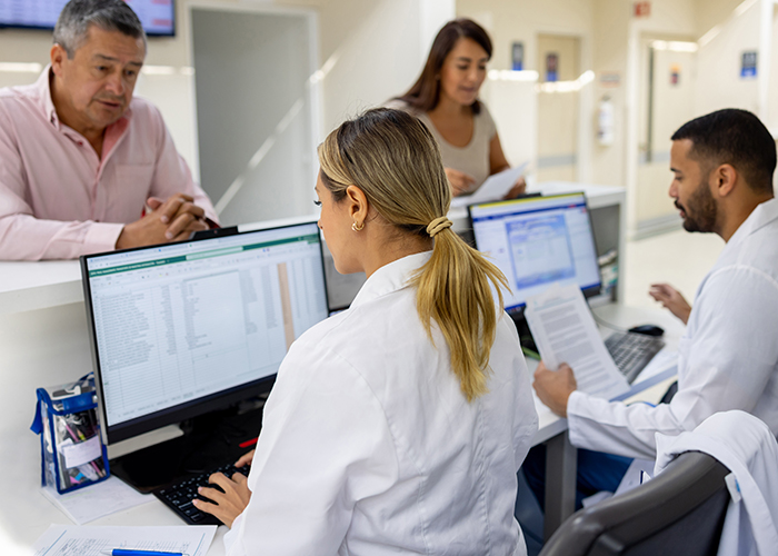 Medical receptionists check in patients at a doctor's office.