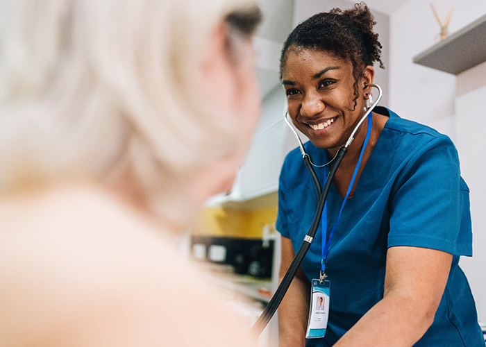 Female nurse listens to a patient's heartbeat.