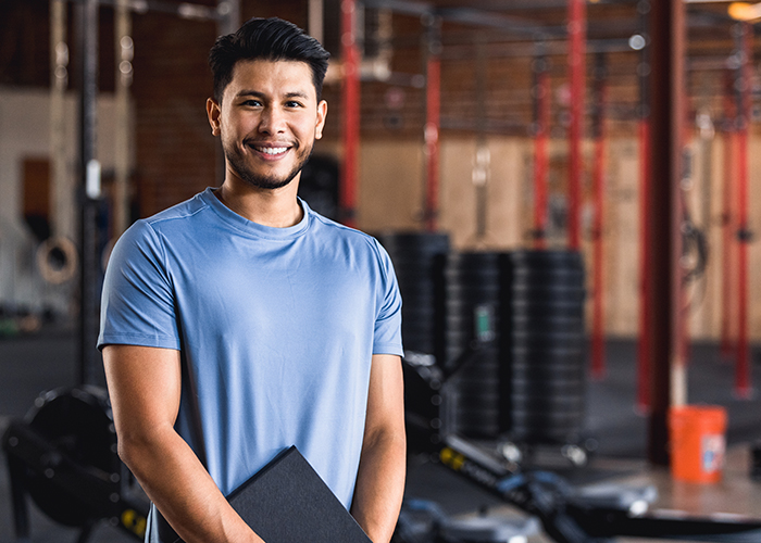 A male personal fitness trainer in a gym.