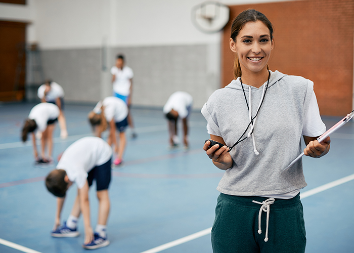 A female PE teacher with kids in the background