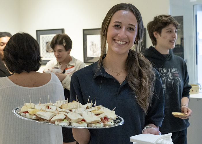 A female hospitality management student with a tray of food.