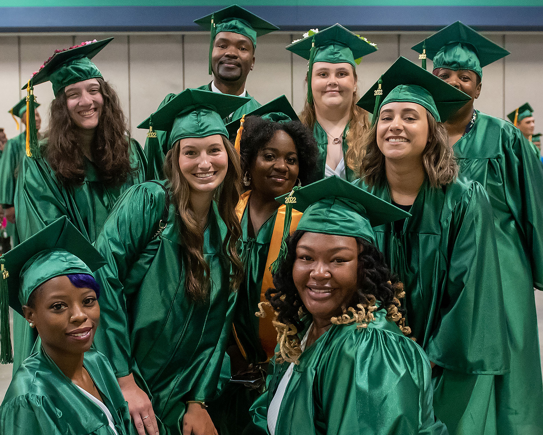 Group of students in regalia smile for a graduation picture