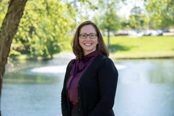 Profile of Anne Simpson with campus lake behind her.