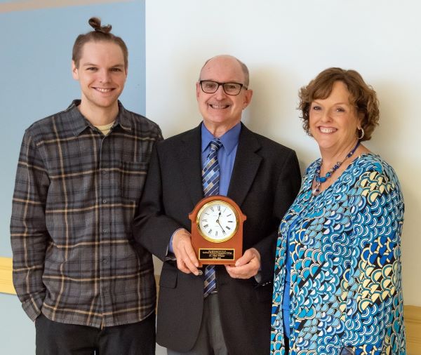 Mark Wheeler Ed.D. (center) with his son, Paul, and his wife, Vicky, at his 2023 retirement party.